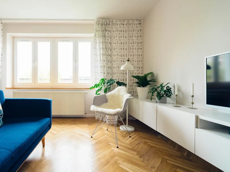 Lys stue med sofa og store vinduer
